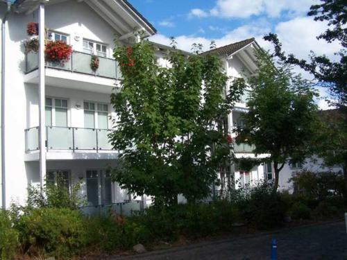 a white building with flower boxes on the balconies at Appartement Granitz - Ferienwohnung Thoenissen in Göhren