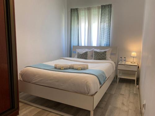 a bedroom with a bed with two towels on it at Barreiro Central Apartment in Barreiro