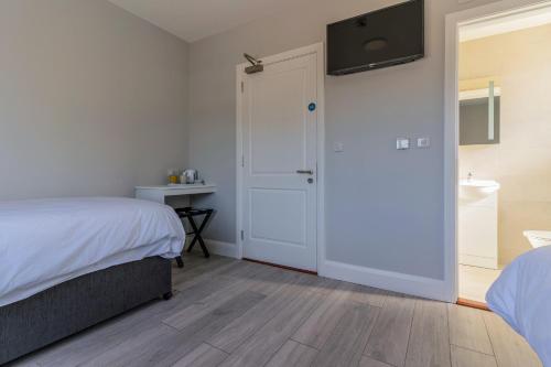 a bedroom with a bed and a sliding door at Sand Dunes Room 3 in Waterford