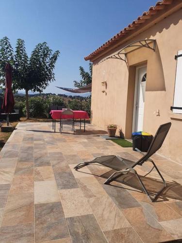 une terrasse avec une table et des chaises dans une maison dans l'établissement Studio mitoyen à la campagne vue sur la mer, à Cargèse
