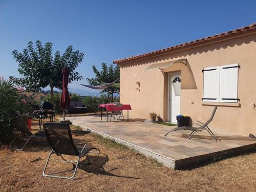 - un ensemble de chaises assises sur une terrasse à côté d'une maison dans l'établissement Studio mitoyen à la campagne vue sur la mer, à Cargèse