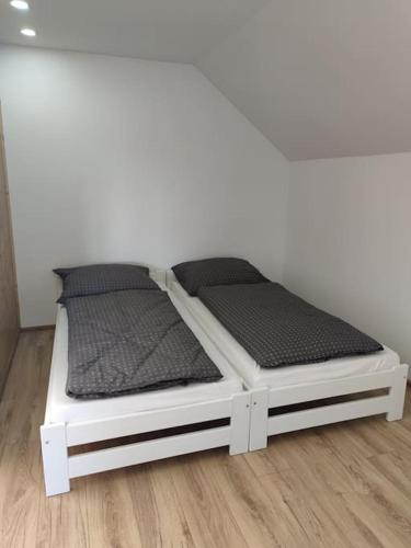2 camas individuales en el suelo de madera en Apartament za lasem, en Kaliska Kośierskie