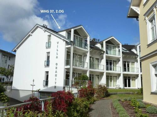 a white apartment building with a roof at Villa Granitz - Ferienwohnung Kettelhoit in Göhren