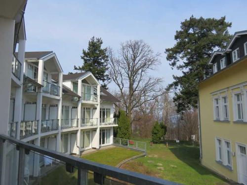 un grupo de edificios con árboles en el fondo en Villa Granitz - Ferienwohnung 29 en Göhren