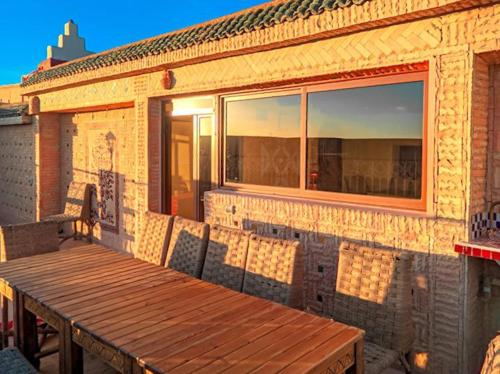 a wooden table on the side of a brick building at Kasbah Assafar in Kalaat MGouna