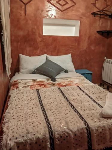 a bedroom with a large bed with pillows at Kasbah Assafar in Kalaat MGouna