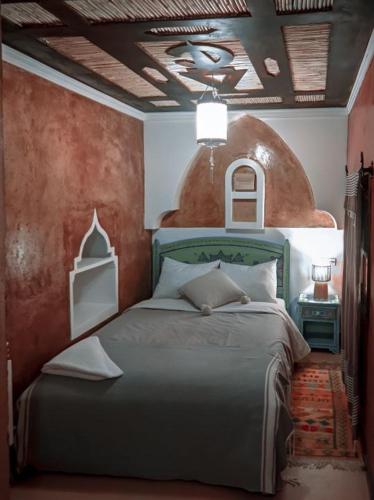 a bedroom with a bed with a red wall at Kasbah Assafar in Kalaat MGouna
