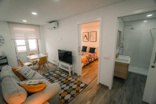 a living room with a couch and a bedroom at Apartamento Mar & Bor - RRAL nº3126 in Praia da Vitória