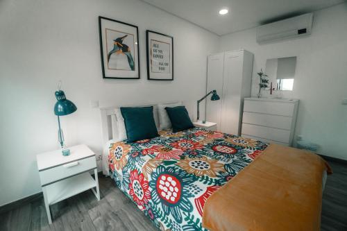 a bedroom with a large bed with a colorful bedspread at Apartamento Mar & Bor - RRAL nº3126 in Praia da Vitória
