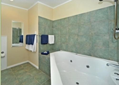 a bathroom with a bath tub and a shower at A'La Vista Motel in Palmerston North
