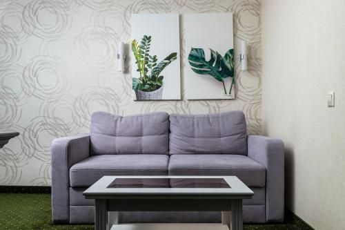a living room with a purple couch and a table at Sonata Hotel & Restaurant "готель Соната" in Lviv