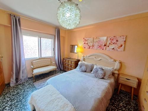 a bedroom with a large bed and a chandelier at Full equipped and comfortable apartment with WiFi in Valencia
