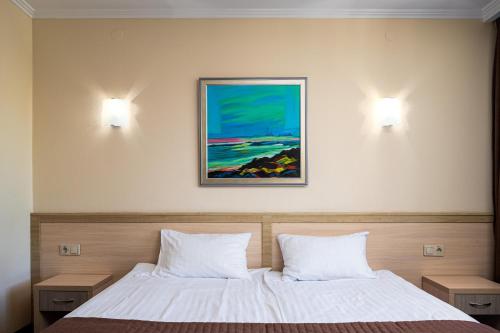 a bedroom with two beds and a painting on the wall at Sonata Hotel & Restaurant "готель Соната" in Lviv