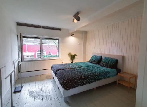 1 dormitorio con cama y ventana en De Fluessen Loft, en Elahuizen