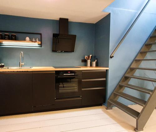 una cocina con fregadero y fogones y una escalera en De Fluessen Loft, en Elahuizen