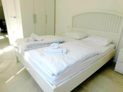 a white bed with white sheets and towels on it at Cankar's secret place in Ljubljana