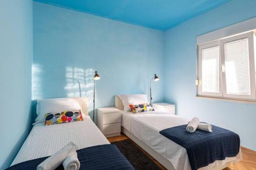 two beds in a room with blue walls at Apartment Blue in Stobreč