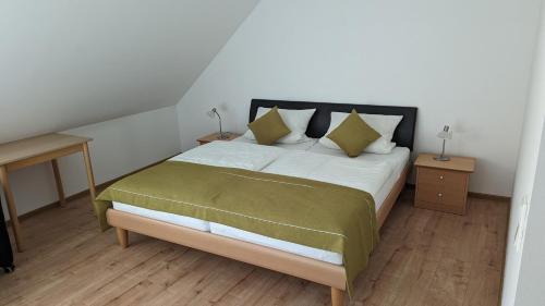 a bedroom with a large bed with a green blanket at Gasthof zum Lehnerwirt in Breitenbrunn