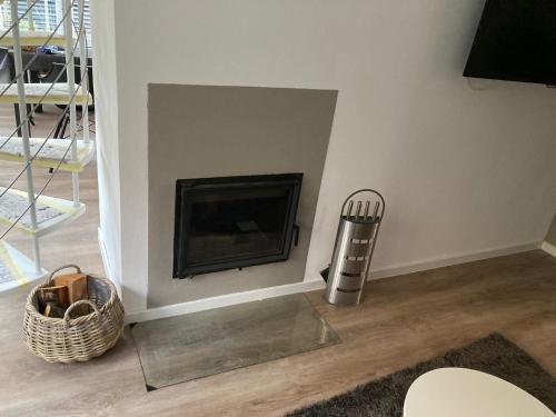 a fireplace in the corner of a living room at Holiday Home Noordwijkerhout by Beach in Noordwijkerhout