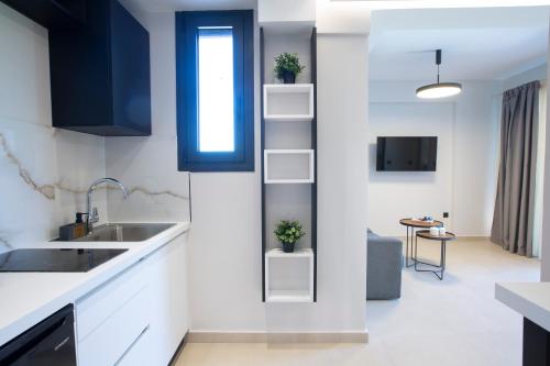 a kitchen with white counters and blue cabinets at Arente Apartments in Lefkada Town