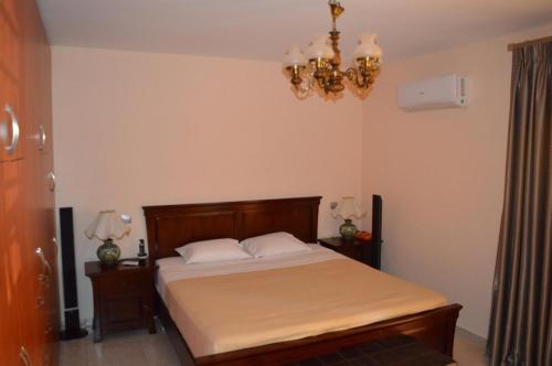 um quarto com uma cama e um lustre em VILLA AVATOS - Near to the port of Rafina and the airport of Athens em Áyios Spirídhon