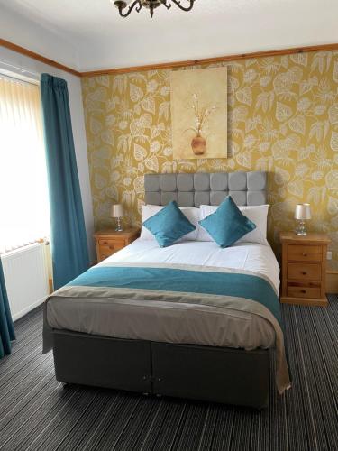 a bedroom with a large bed with blue pillows at Inchrye Bed & Breakfast in Inverness