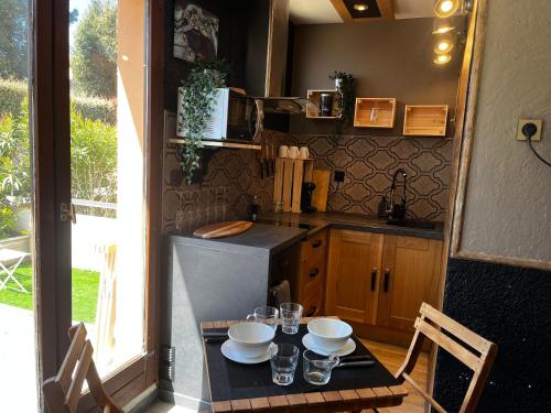 - une cuisine avec une table avec des bols et des verres dans l'établissement Joli studio ensolleillé, à Cavalaire-sur-Mer