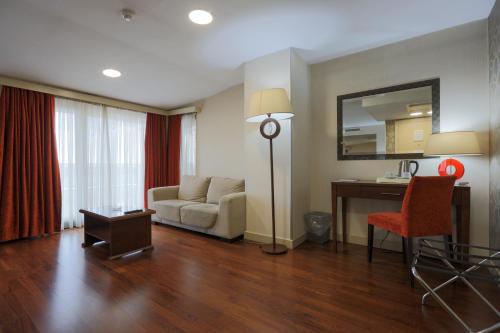 a living room with a couch and a desk at Niza Park Hotel in Ankara