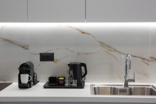 a kitchen counter with a sink and a coffee maker at Arente Apartments in Lefkada Town