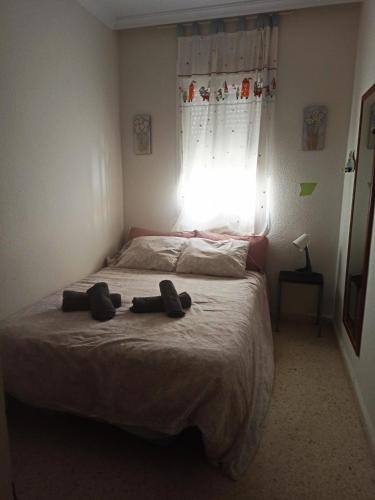a bedroom with a bed with two slippers on it at El Rincón de Umbria in Punta Umbría