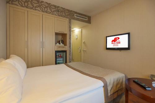 a bedroom with a bed and a tv on the wall at Niza Park Hotel in Ankara