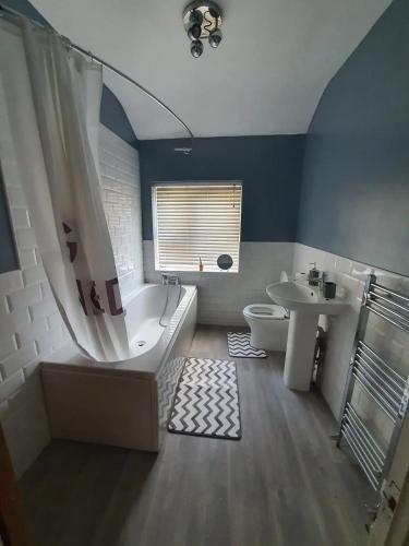a bathroom with a tub and a toilet and a sink at Private BedroomC Greater Manchester in Middleton