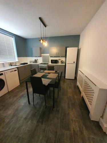 米德頓的住宿－Private BedroomC Greater Manchester，厨房配有桌椅和冰箱。