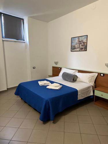 a bedroom with a bed with a blue blanket at Hotel Mercurio in Milan