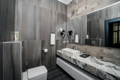 a bathroom with a sink and a toilet and a mirror at Hills Resort Hotel in Yerevan