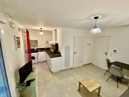 un salon avec une table et une cuisine dans l'établissement PAUL DOUMER #1 By SCLS Locations, au Cannet