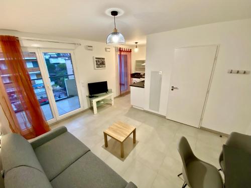 un salon avec un canapé et une table dans l'établissement PAUL DOUMER #1 By SCLS Locations, au Cannet