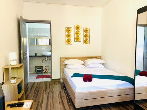 - une chambre dotée d'un lit avec un archet rouge dans l'établissement Moya Résidence by MD, à Dzaoudzi