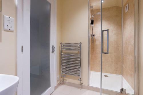 a bathroom with a shower and a toilet and a sink at Garn Yam Cottage in Ambleside