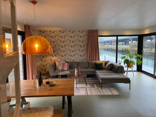 ein Wohnzimmer mit einem Sofa und einem Tisch in der Unterkunft Unieke woonark met privétuin en free parking. in Rotterdam