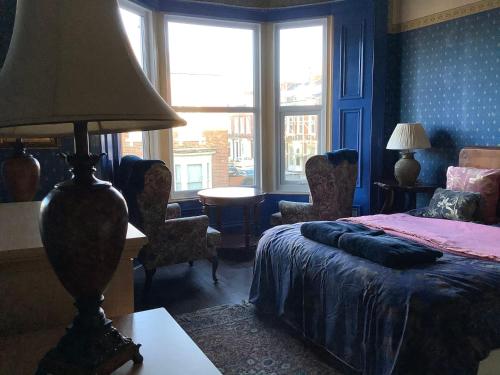 a bedroom with a bed and a table with a lamp at Rooms in City House nr Light Stadium in Sunderland
