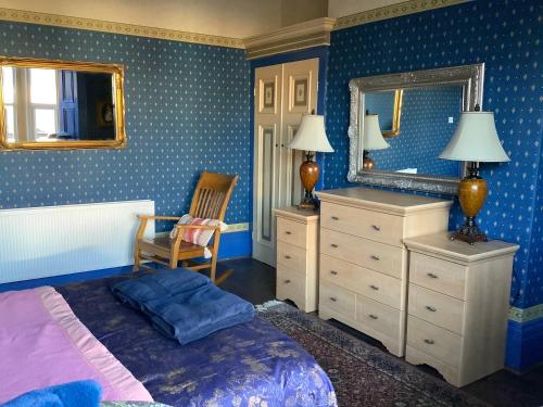 a bedroom with a bed and a mirror and a chair at Rooms in City House nr Light Stadium in Sunderland