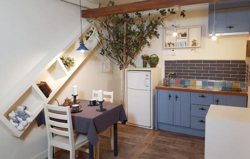 a kitchen with a table and a kitchen with blue cabinets at Olive Vanilla Pension in Gyeongju