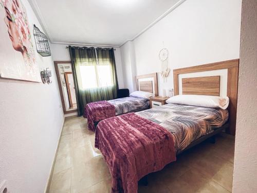 a hotel room with two beds and a window at HomeXperience in San Pedro del Pinatar