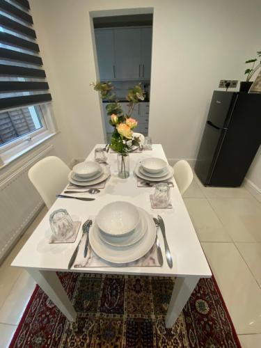 una mesa blanca con platos y utensilios. en B&T Pleasure Homes - Southend, en Southend-on-Sea