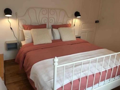 a bedroom with a large bed with red and white pillows at Mirabel in Beaulieu-sur-Dordogne