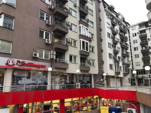 un grand bâtiment avec une bannière rouge devant lui dans l'établissement VD Apartment, à Skopje