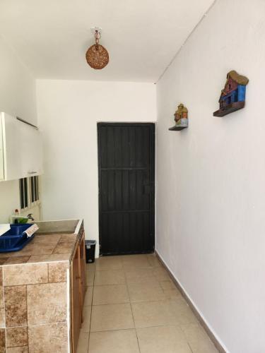 una cucina con porta nera e parete bianca di LoftJaguar a Palenque