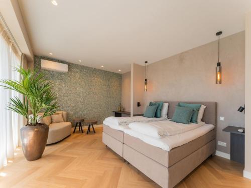 een slaapkamer met een groot bed en een potplant bij Modern water villa in Zeewolde with jetty in Zeewolde
