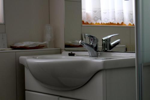 a bathroom with a white sink and a mirror at Gasthof Ölberg in Innsbruck